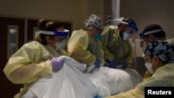 Healthcare personnel rotate a patient who is on a ventilator at a hospital in Hutchinson, Kansas, Nov. 20, 2020.