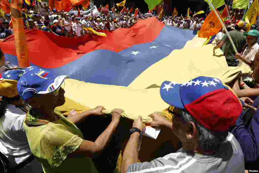 La bandera venezolana es ondeada entre los manifestantes opositores.