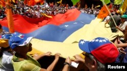 Pendukung oposisi kibarkan bendera national dal am demo menentang pemerintah Presiden Venezuela Nicolas Maduro