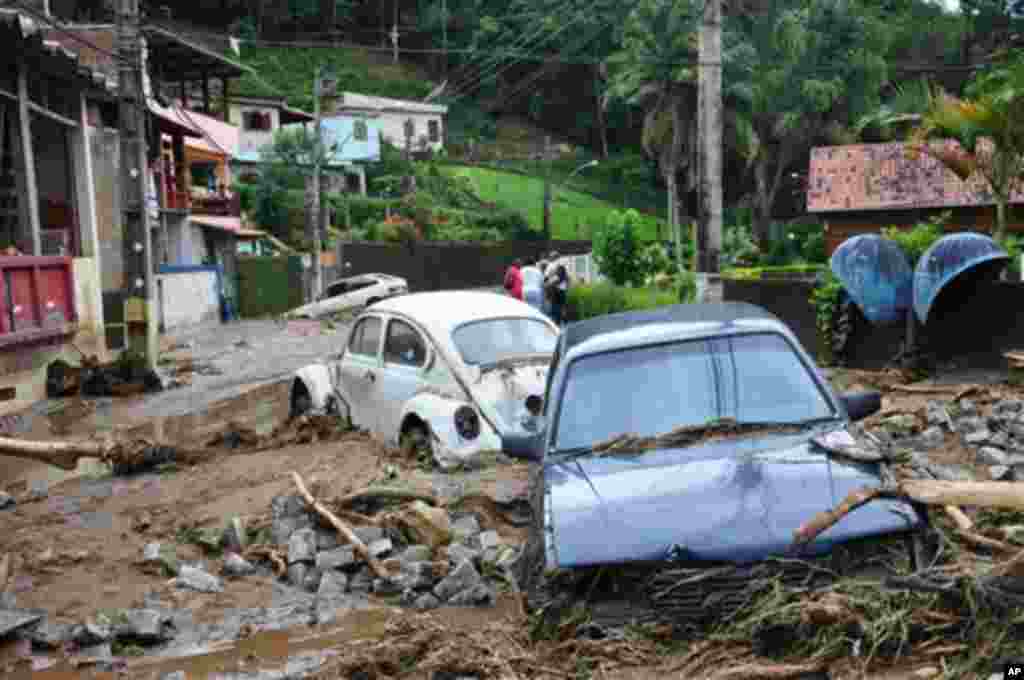 Carros atolados em lama e entulho, numa rua de  Teresópolis, nos arredores do Rio de Janeiro.
