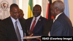 Rebel leader Riek Machar (center) looks on negotiators sign an agreement last November recommitting both sides to ending hostilities.
