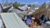 Afghan families who have been displaced due to fighting between Taliban and Afghan forces, take temporary shelter at a market in Mihtarlam, the capital of Laghman Province on May 24, 2021.