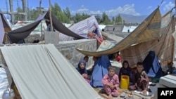 Afghan families who have been displaced due to fighting between Taliban and Afghan forces, take temporary shelter at a market in Mihtarlam, the capital of Laghman Province on May 24, 2021.
