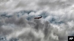 An airliner takes an approach through storm clouds to Hollywood Burbank Airport, in Burbank, Calif., Dec. 25, 2021. 