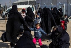 FILE - Women and children are seen in the Kurdish-run al-Hol camp which holds suspected relatives of Islamic State (IS) group fighters, in Hasakeh governorate in northeastern Syria, Jan. 28, 2021.
