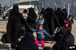 FILE - Women and children are seen in the Kurdish-run al-Hol camp which holds suspected relatives of Islamic State group fighters, in Hasakeh governorate in northeastern Syria, Jan. 28, 2021.