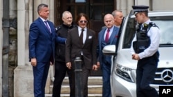 File - Johnny Depp, center, leaves the High Court, in London, July 10, 2020. 