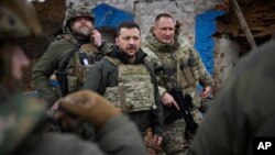 En esta imagen proporcionada por la oficina de presidencia de Ucrania, el presidente de Ucrania, Volodymyr Zelenskyy, en el centro, durante su visita a la región de Zaporiyia, donde se producen intensos combates con tropas rusas, en Ucrania, el domingo 4 de febrero de 2024. 