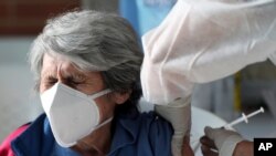 Una mujer recibe su primera inyección de la vacuna Sinovac COVID-19 de China durante un programa de vacunación prioritaria para personas mayores en Bogotá, Colombia, el martes 9 de marzo de 2021.