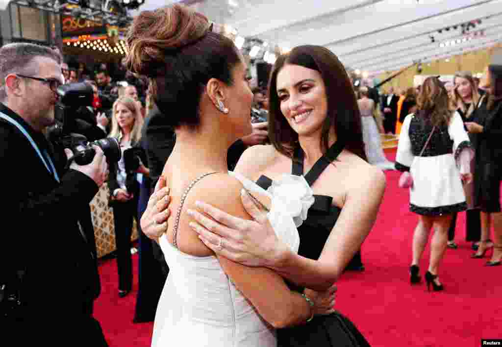 Penelope Cruz talks with Salma Hayek on the red carpet during the Oscars arrivals at the 92nd Academy Awards in Hollywood, Feb. 9, 2020. 