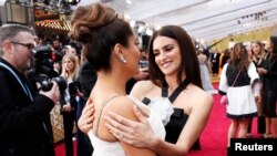 Penelope Cruz talks with Salma Hayek on the red carpet during the Oscars arrivals at the 92nd Academy Awards in Hollywood, Feb. 9, 2020. 