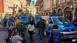 FILE - Police vans stand in downtown Muenster, Germany.