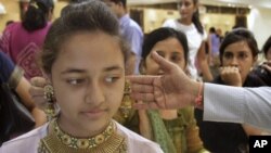 People shop for gold jewelry in Ahmadabad, India, May 6, 2011, during the Hindu festival " Akshay Tritiya", which is considered auspicious for buying gold. Indian-Americans' love affair with gold has made them targets for criminals.