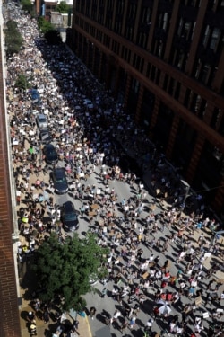 Protesters march in the street on June 7, 2020, in St. Louis, Mo.