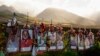 FILE - Foto para korban dipajang di bawah salib putih pada peringatan korban kebakaran hutan Agustus 2023, di atas jalan raya Lahaina Bypass, 6 Desember 2023, di Lahaina, Hawaii. (AP/Lindsey Wasson)