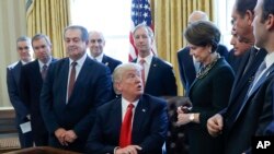 Presiden Donald Trump berbincang dengan Pimpinan, Presiden dan CEO Lockheed Martin Marillyn Hewson (kanan) sebelum menandatangani inpres di Kantor Oval, Gedung Putih, Washington, Jumat, 24 Februari 2017. (Foto: dok).