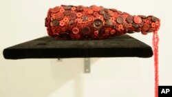 “A Harlem Hangover,” by Beau McCall simulating a spilled wine bottle, is on display for The Button Show at the Rush Arts Gallery, Jan. 20, 2016, in New York. Clothing buttons are re-imagined as an artistic medium in contemporary art in the show running through March 12.