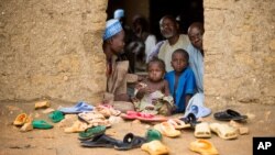 FILE - Refugees sit at the door of their home at the Minawao Refugee Camp in northern Cameroon.