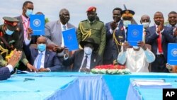 FILE - Sudan's transitional authorities and a rebel alliance sign a peace deal initialed in August that aims to put an end to the country's decades-long civil wars, in a televised ceremony in Juba, South Sudan, Oct. 3, 2020.