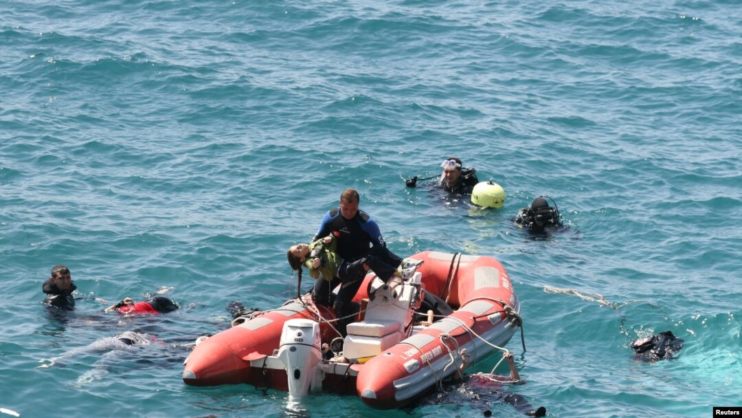 A diver from the Turkish sea police (C) carries a girl in a rescue boat as other divers look for victims in the Aegean sea off Menderes, western Turkey, September 6, 2012.