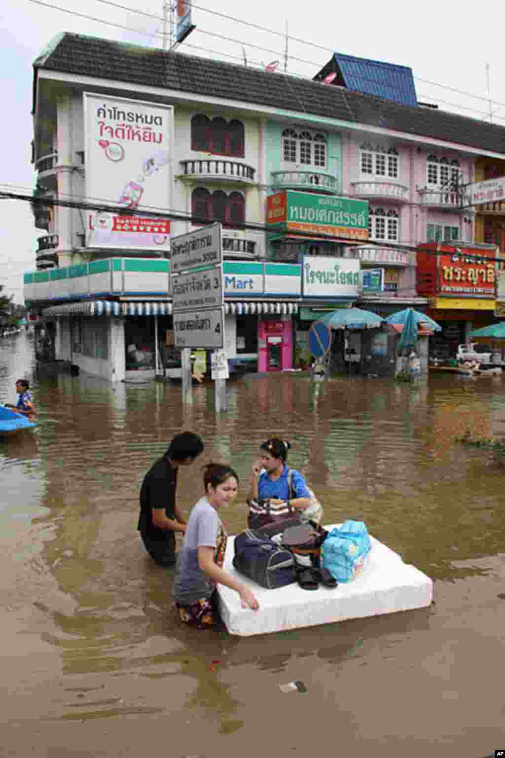 Ayutthaya residents float belongings out of a flooded neighborhood, October 6, 2011. (VOA - D. Schearf)