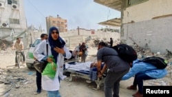 Sejumlah warga Palestina berjalan meninggalkan Rumah Sakit Kamal Adwan menyusul serangan Israel ke wilayah Beit Lahia, di utara Jalur Gaza, pada 21 Mei 2024. (Foto: Reuters/Osama Abu Rabee)