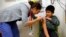 A boy gets an influenza vaccine injection at a health care clinic, in Boston, Massachusetts, January 12, 2013.