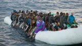 FILE - Migrants and refugees crowd aboard a rubber boat sailing out of control in the Mediterranean Sea about 21 miles north of Sabratha, Libya, Feb. 3, 2017.