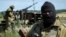 Pro-Russian fighters stand patrol near Luhansk, eastern Ukraine, July 2, 2014. 