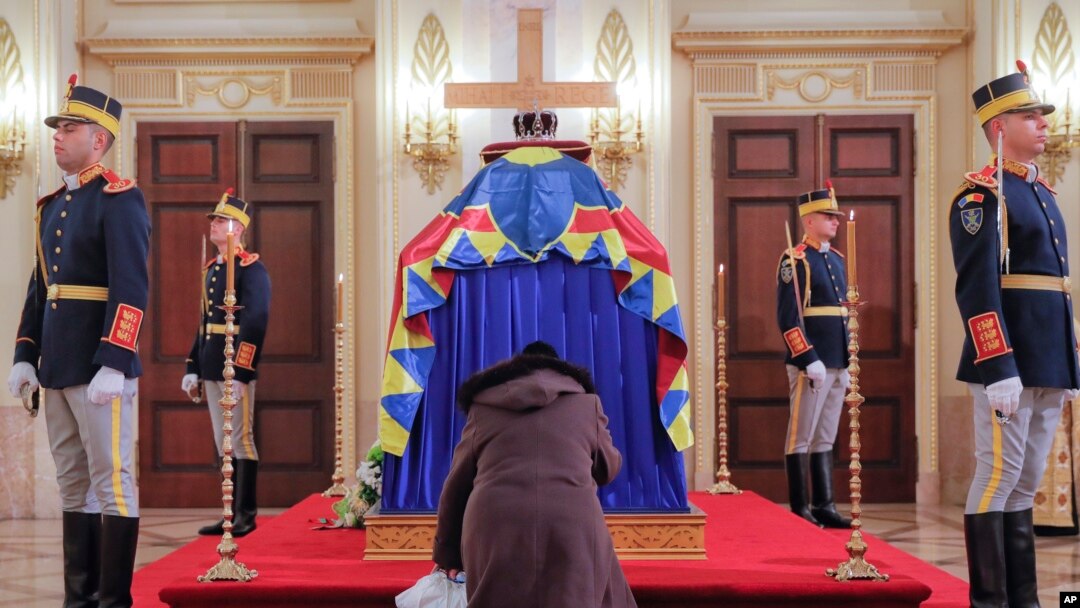 Seorang perempuan berlutut di samping peti jenazah mendiang Raja Rumania Michael, di bekas istana kerajaan Rumania di Bucharest, 14 Desember 2017.