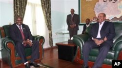 Shugaban tawagar Sudan ta Kudu, Pagan Amum, a hagu, tare da shugaba Omar al-Bashir a Khartoum, Sudan, ranar alhamis 22 Maris, 2012, lokacin wata ziyarar da 'yan Sudan ta Kudu suka kai domin shirya ganawa a tsakanin shugabannin kasashensu biyu. 