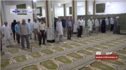 Iranian men adopt unusual social distancing at a reopened mosque in Kahnouj, Kerman province while ignoring a government requirement to wear face masks, in this May 5, 2020 report on Iranian state TV.
