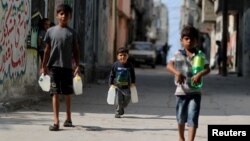 Anak-anak Palestina membawa botol-botol air ke kamp pengungsi Al-Shati di kota Gaza (foto: dok). Laporan PBB menyatakan, air tidak mencukupi  di Tepi Barat, Yerusalem Timur dan Gaza. 