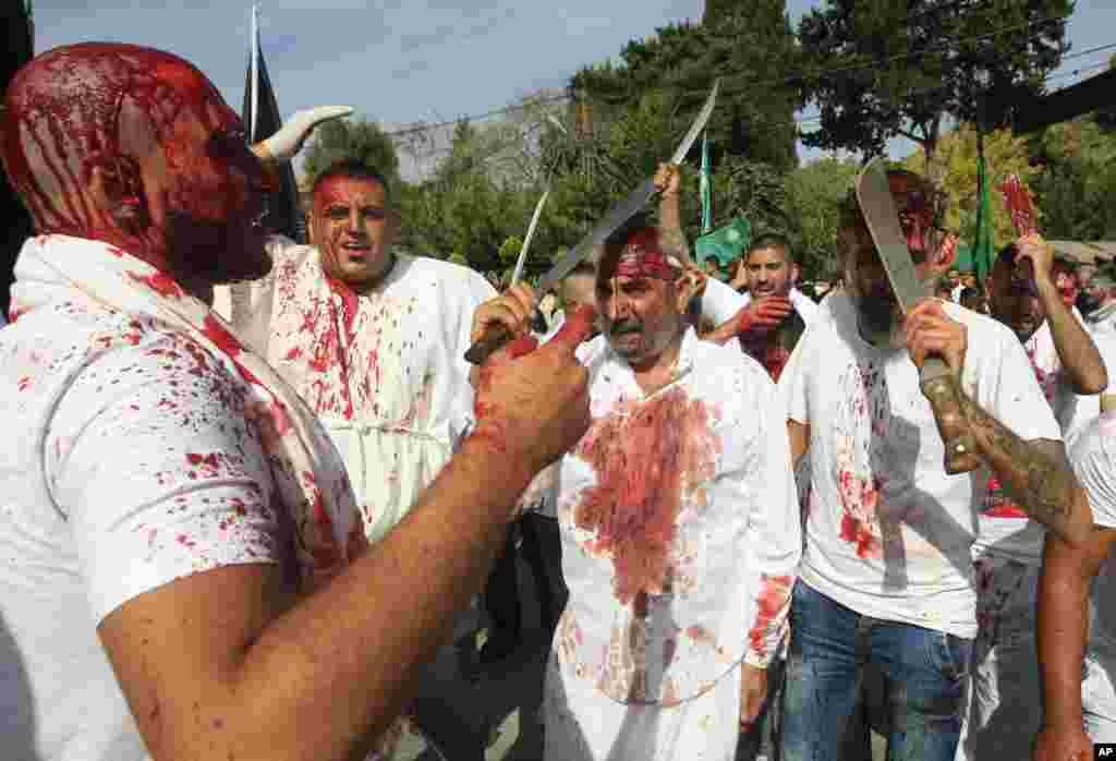 Para pria Muslim Syiah di kota Nabatiyeh, Lebanon, berdarah dari luka-luka irisan pedang yang mereka lakukan sendiri, untuk menunjukkan rasa luka yang mendalam dalam ritual Ashura (12/10). (AP Photo/Mohammed Zaatari)