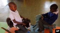 FILE - Children play on rocking horses at a toy library run by Cotlands, a local nonprofit organization that promotes early learning opportunities for children, in Johannesburg. 