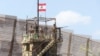 FILE - Lebanese army members stand on an observation tower in Naqoura, near the Lebanese-Israeli border, southern Lebanon, Aug. 8, 2023. The Israeli military reportedly has withdrawn from the town following a ceasefire agreement reached in November 2024. 