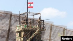 FILE - Lebanese army members stand on an observation tower in Naqoura, near the Lebanese-Israeli border, southern Lebanon, Aug. 8, 2023. The Israeli military reportedly has withdrawn from the town following a ceasefire agreement reached in November 2024. 