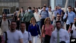 On what has been dubbed "Freedom Day", marking the end of coronavirus restrictions in England, people walk over London Bridge a popular walking route for commuters from London Bridge train and tube stations in London.