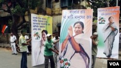 Pendukung partai Kongres memasang gambar Mamata Banerjee di Kolkata (13/5). Partai Kongres menang 215 kursi dari 294 kursi yang diperebutkan di Benggala barat, menyingkitkan dominasi partai Komunis.