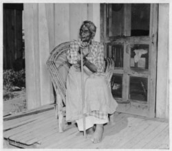 FILE - Lucinda Davis, guessed to be 89 years-old at the time, sits on the front porch of her home in Tulsa, Oklahoma, Aug. 16, 1937. She was the former slave of a full-blooded Muscogee Creek farmer named Tuskaya-hiniha. (Library of Congress)