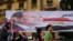 Egyptians walk by a poster for former Egyptian army chief Abdel Fattah al-Sisi in Tahrir square as they arrive to celebrate his victory in the presidential vote in Cairo, June 3, 2014.