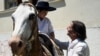 Uruguay's President Luis Lacalle talks to a boy dressed as a gaucho who gave him a rope lasso before casting his vote during the presidential runoff election in Canelones, Uruguay, Nov. 24, 2024. 