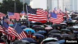 Para pengunjuk rasa anti-pemerintah melambaikan bendera AS saat demonstrasi di Hong Kong, China, 15 September 2019. (Foto: Jorge Silva/ Reuter)