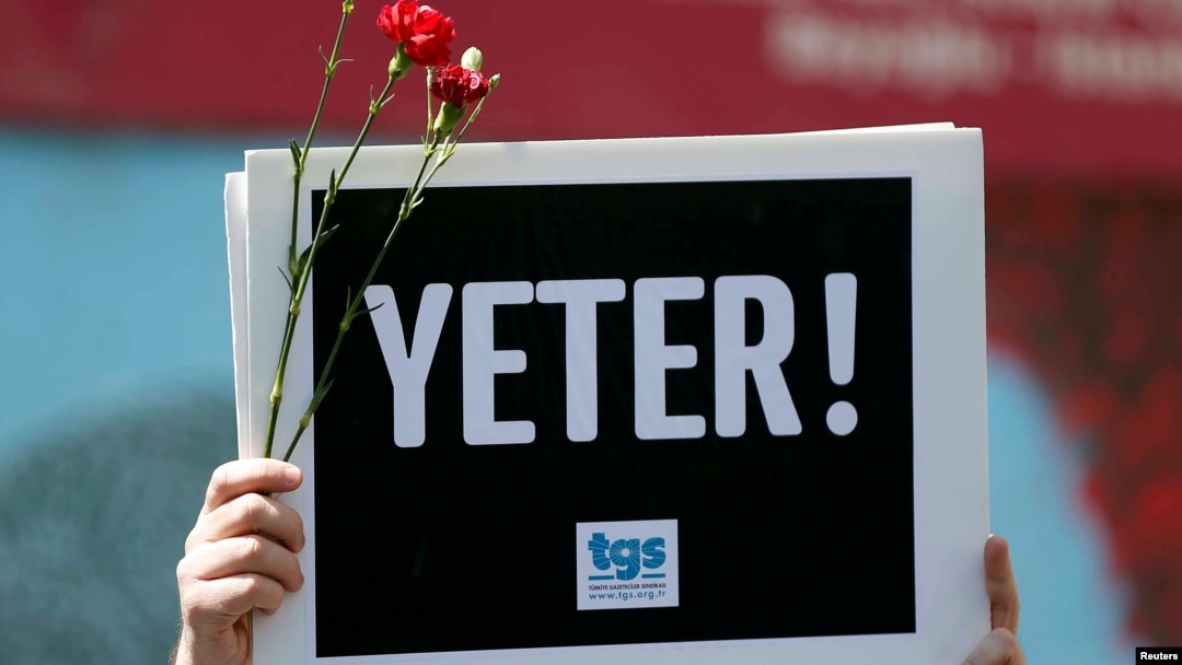 A member of the Journalists Union of Turkey (TGS) holds a placard reading "Enough!" during a demonstration to mark World Press Freedom Day in central Istanbul, Turkey, May 3, 2017.