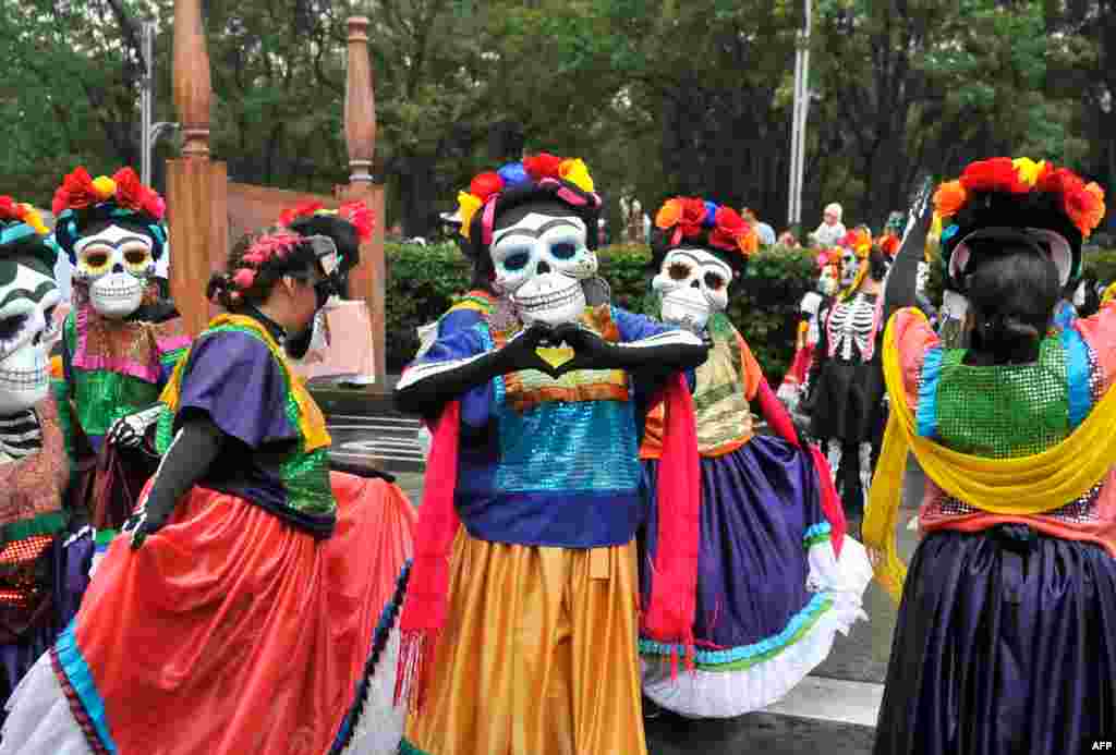 People take part in the Day of the Dead parade along Reforma avenue in Mexico City, Oct. 27, 2019.