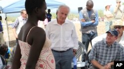 U.S Senators Bob Corker, center, and Chris Coons, right, speak with a South Sudanese refugee during a group discussion at the Bidi Bidi refugee settlement in northern Uganda, April 14, 2017.