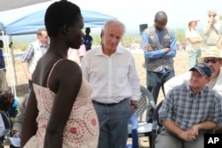 U.S Senators Bob Corker, center, and Chris Coons, right, speak with a South Sudanese refugee during a group discussion at the Bidi Bidi refugee settlement in northern Uganda, April 14, 2017.