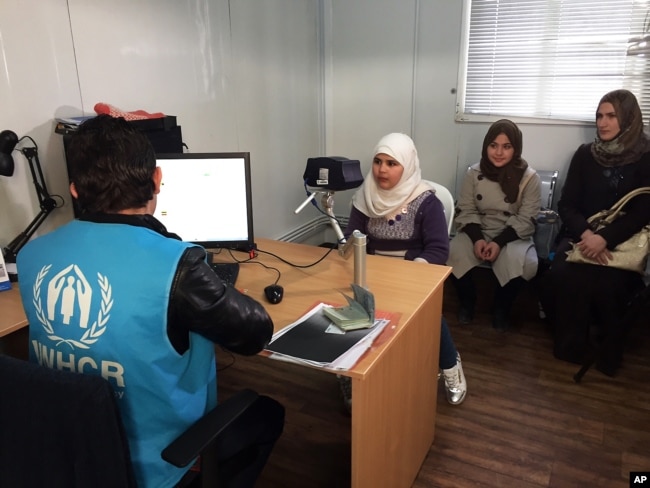 FILE - Biometric identification systems are being used in novel ways. In this photo, a Syrian refugee girl poses for a biometric iris scan in a U.N. office in Amman, Jordan, an intial step in her efforts to be approved for resettlement in the West. Somaliland has become the first to employ iris-scanning technology to identify voters.