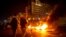 Protesters smoke water pipes in front burning tires that were set on fire to block a road, at Martyrs' Square, in downtown Beirut, Lebanon, March 6, 2021. 