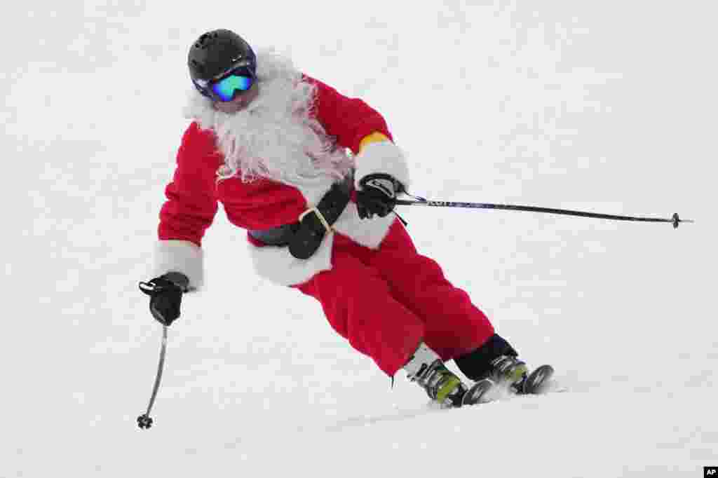 A skier dressed as Santa Claus skis for charity at the Sunday River Ski Resort, Dec. 11, 2022, in Newry, Maine.